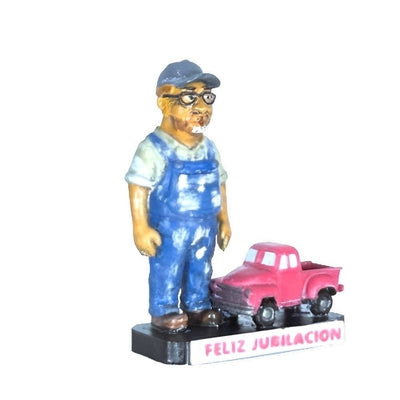  Figura de jubilado con mono azul y gorra, vista tres cuartos derecha, junto a camioneta rosa con base 'Feliz Jubilación'