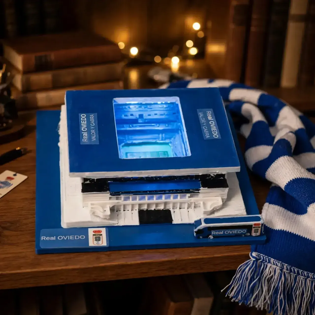 Maqueta del Estadio Carlos Tartiere del Real Oviedo con luz LED azul sobre escritorio de coleccionista con bufanda oficial