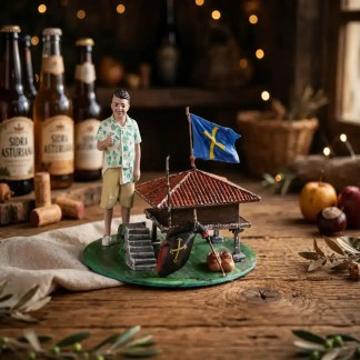 Figura coleccionista de hórreo asturiano con tejado rojo, paisano con camisa hawaiana haciendo gesto ok, bandera de Asturias con Cruz de la Victoria, bota y madreñas sobre base verde prado