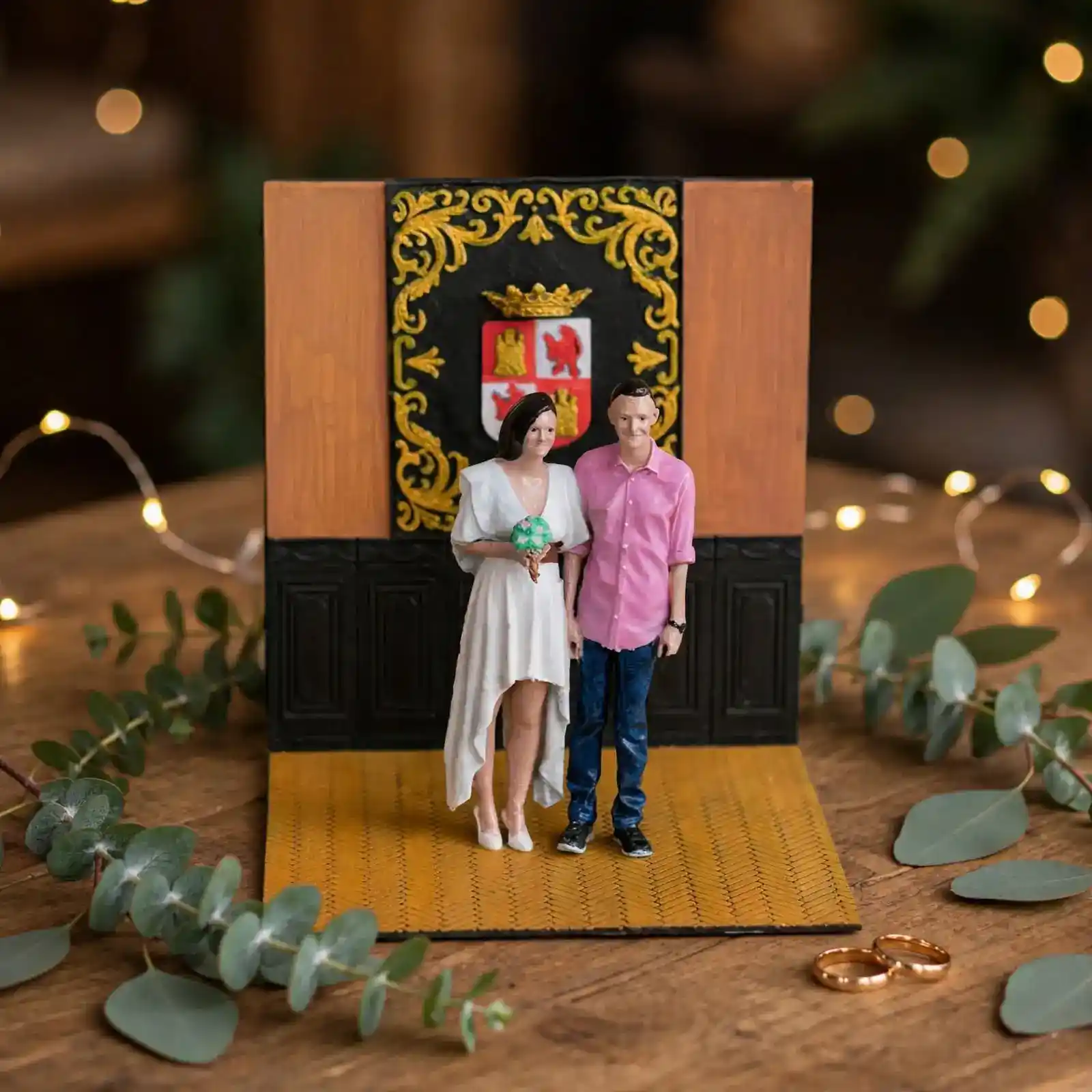 Diorama boda civil pareja en mesa madera con hojas eucalipto anillos de boda oro y luces cálidas fondo romántico regalo boda